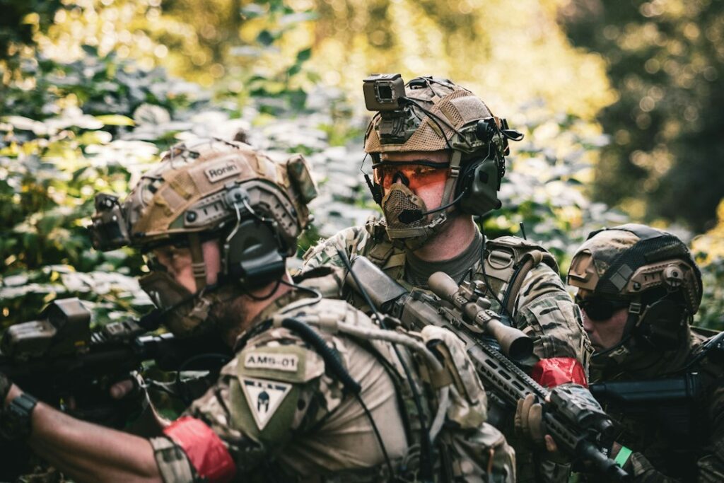 Airsoft players taking part in a woodland game while wearing protective equipment